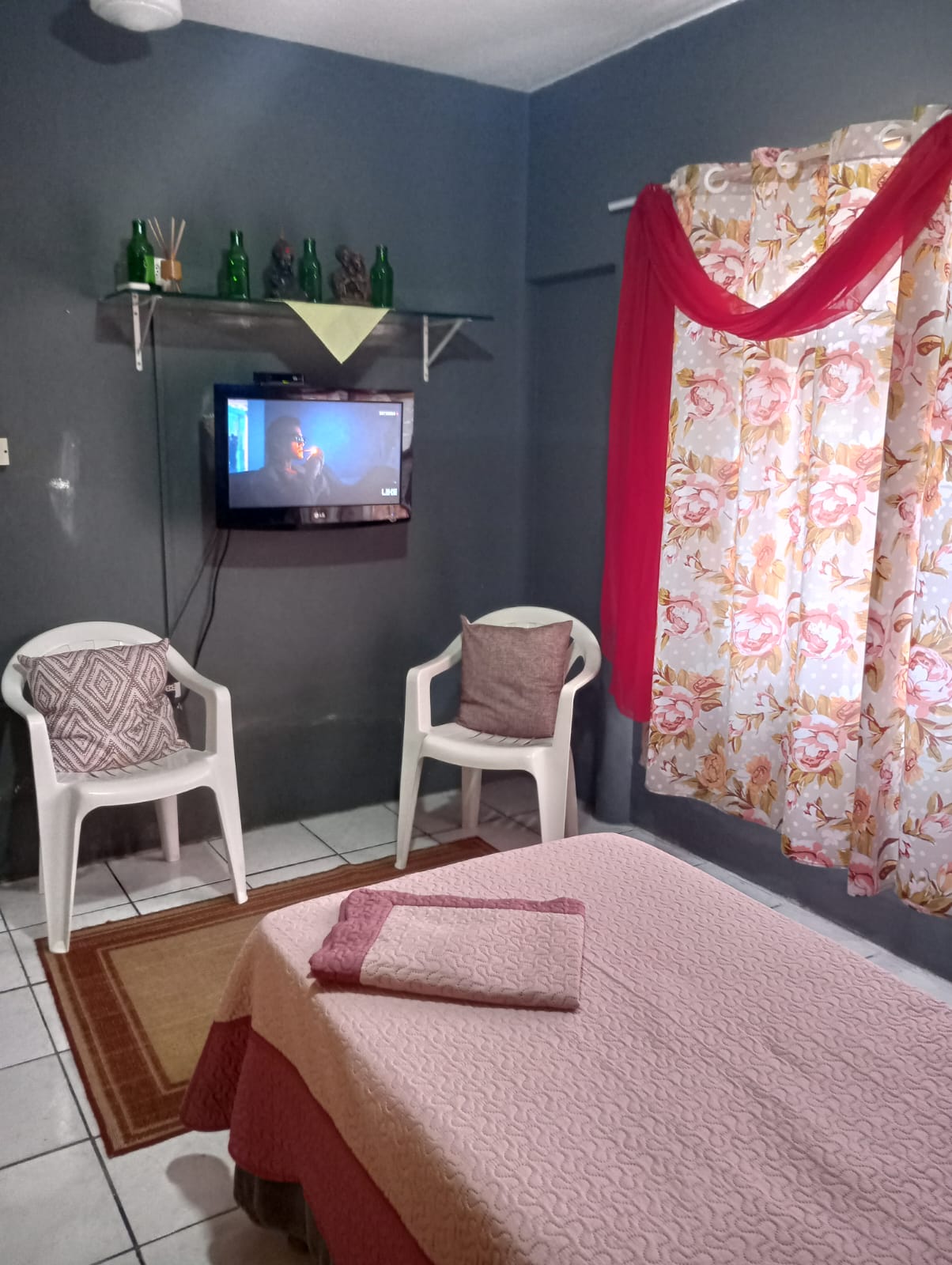 Ambiente com cama, TV e cadeiras